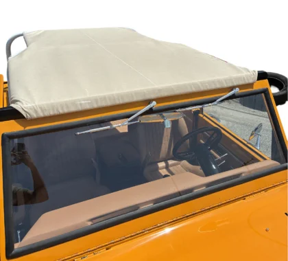 Overhead view of an orange vintage car with a tan bimini top, windshield, and brown interior.