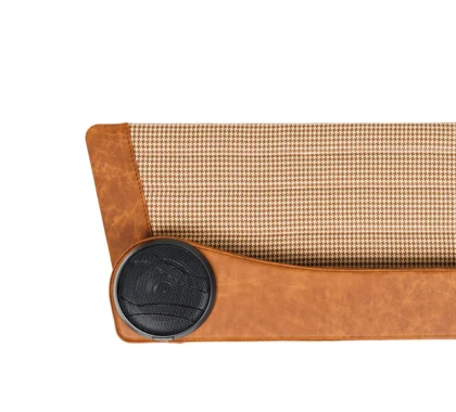 Close-up of a brown houndstooth fabric panel with a circular black speaker and tan leather trim.